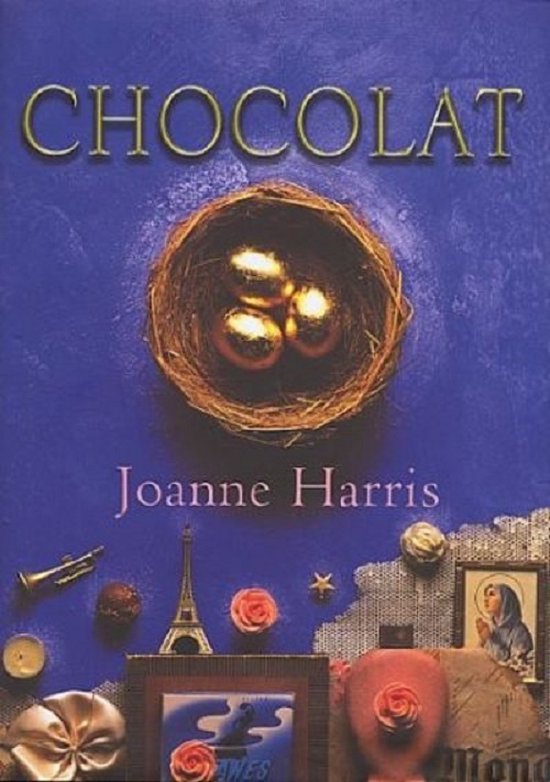 Boek "Chocolat" van Joanne Harris, met gouden eieren in een nest, Eiffeltoren, kaars en rozen.