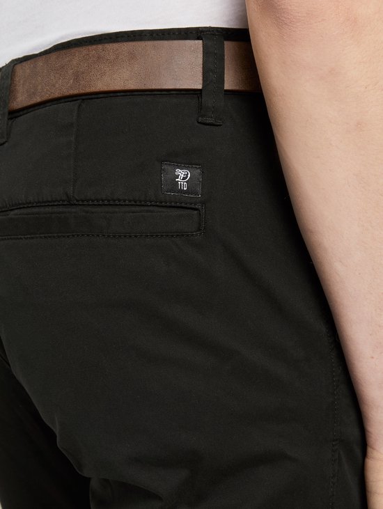 Zwarte chino met een bruine riem en het "TTD" logo op de achterzak.