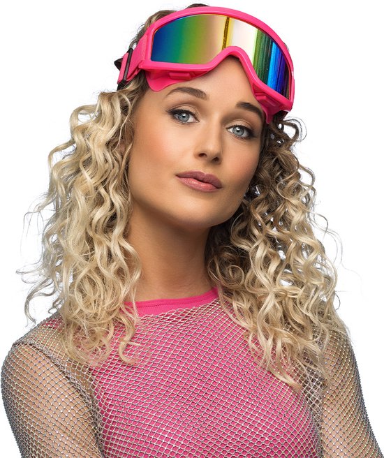 Een vrouw met krullend blond haar draagt een felroze skibril met regenboogspiegelglas.