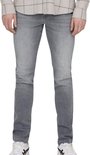 Man in slim fit grijze jeans en een geblokt shirt met bruine lijnen. Schoenen met witte veters.