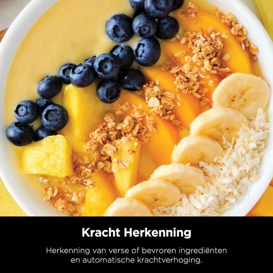 Close-up van een smoothie bowl met mango, blauwe bessen, banaan, granola en kokosvlokken.