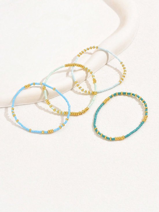 Vier armbandjes met lichtblauwe, turquoise, lichtgroene en gouden kraaltjes.