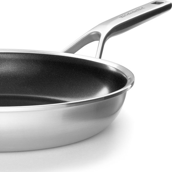 Close-up van een KitchenAid koekenpan met een zilverkleurig handvat en een donkere antiaanbaklaag.