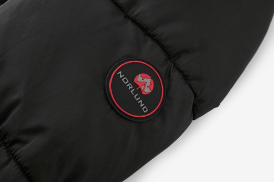Detail van de zwarte jas met een rond NORLUND logo met rode rand.