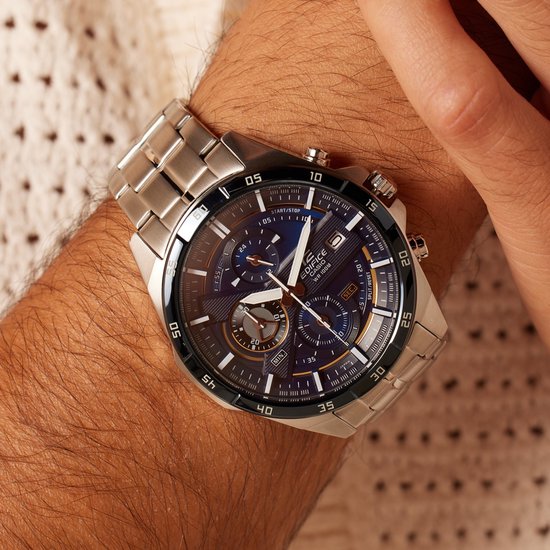 Zilverkleurig Edifice horloge met donkerblauwe wijzerplaat, gedragen op een mannelijke pols.