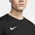 Gros plan d'un homme aux taches de rousseur, portant un t-shirt de sport noir avec logo Nike blanc sur la poitrine.