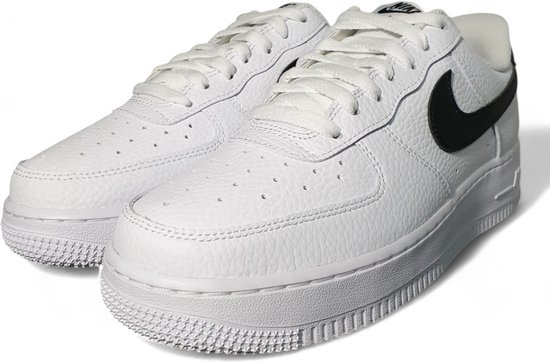 Paar witte sneakers van generfd leer met zwart Swoosh logo. Zwart op de hiel.
