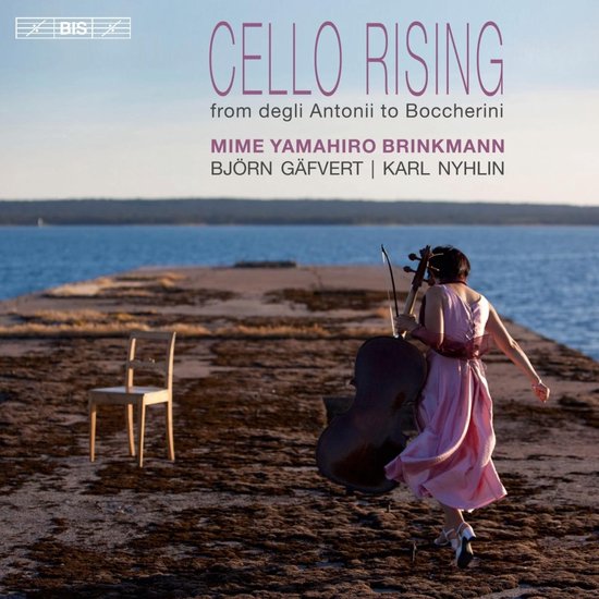 Vrouw in roze jurk met cello op een pier aan zee. Titel: Cello Rising.