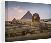 Tableau sur toile Le Sfynx devant les pyramides égyptiennes sous le soleil couchant - 90x60 cm - Décoration murale Art