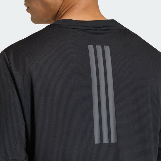 Detail van de achterkant van een zwart Adidas performance shirt met drie reflecterende strepen op de schouderbladen.