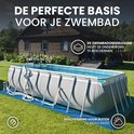 Een opzetzwembad staat op een blauwe beschermmat in een tuin. De mat is ideaal voor buiten en beschermt de ondergrond.