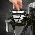 Close-up van de RVS kan van een koffiezetapparaat, die warmte afgeeft. Vier mokken koffie.