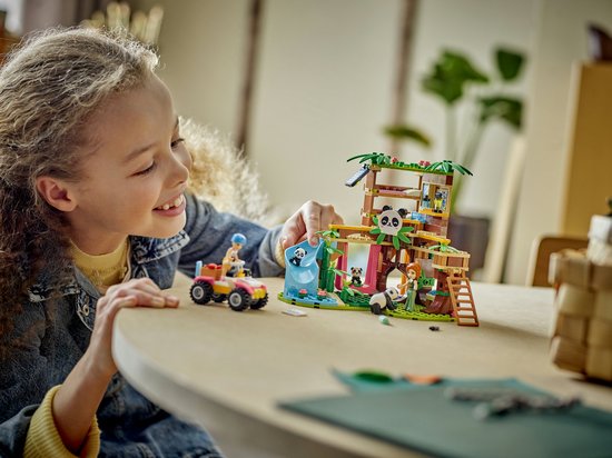 Meisje speelt met de LEGO Friends Pandaopvang boomhut, glijbaan en quad.