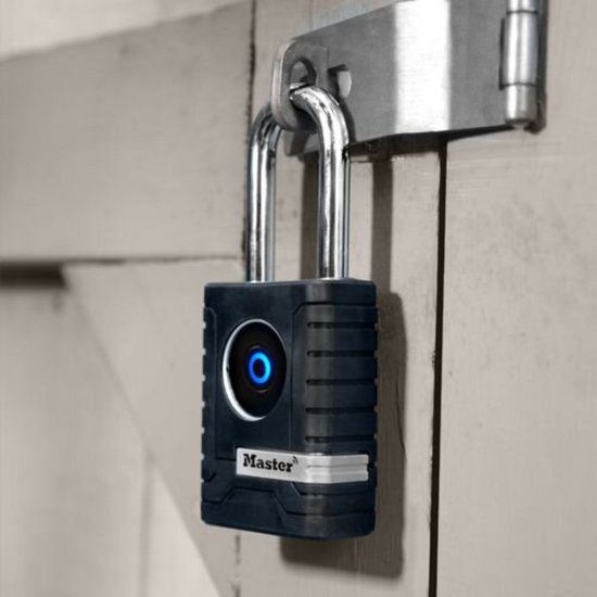 Zwart MasterLock hangslot met zilveren beugel en blauw oplichtend Master Lock logo, bevestigd aan houten deur.