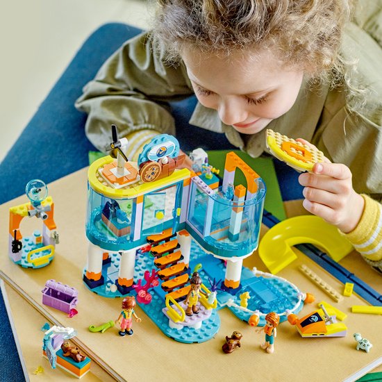 Meisje speelt met het LEGO Friends Reddingscentrum op zee. Met gebouw, glijbaan, poppetjes en speelgoeddieren.