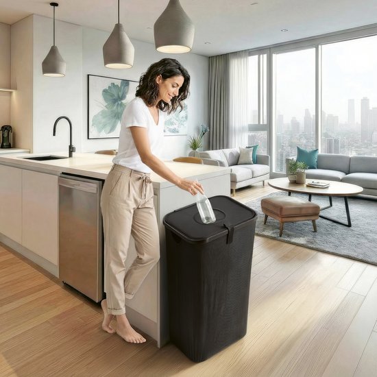 Vrouw in keuken die een fles in een zwarte flessenbak met deksel deponeert. Stijlvol interieur.