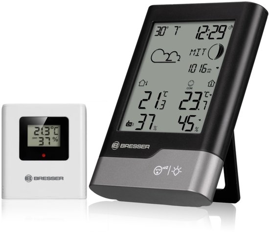 Zwarte Bresser weerstation en witte thermometer met display.
