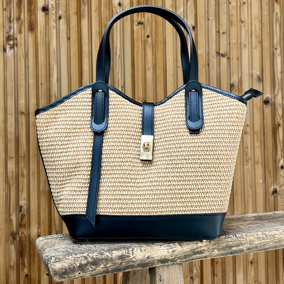 Tas van raffia met zwart leer afgewerkt
