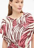 Model draagt een off-white T-shirtjurk met bruine en roze abstracte print en ceintuur in de taille.