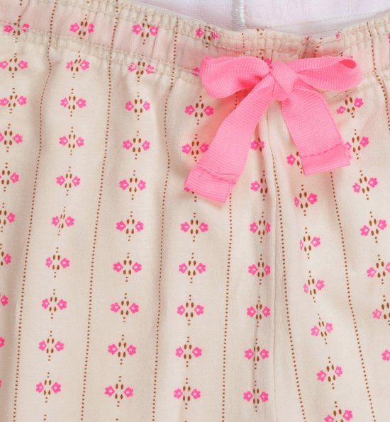 Een lichtgrijze pyjamabroek met verticale strepen, roze bloemetjes, een roze strik en roze biezen.