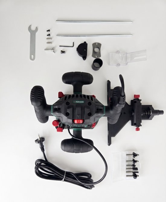Parkside bovenfreesmachine met accessoires: frezen, geleider, sleutel en schroeven, plat gelegd.