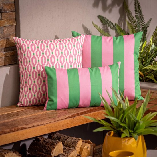 Drie sierkussens op een houten bankje: één met geometrische print, twee met roze en groene strepen.