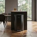 Poubelle à pédale Bayt noire de 30 litres dans une cuisine moderne près d'un îlot.