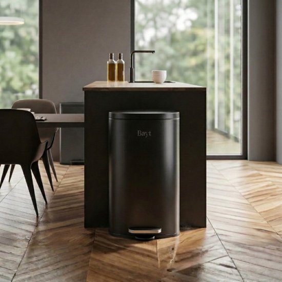 Poubelle à pédale Bayt noire de 30 litres dans une cuisine moderne près d'un îlot.