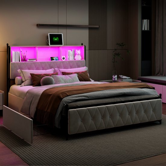 Een beige gestoffeerd bed met hoofdbord met opbergvakken en roze LED-verlichting, met een open zijlade.