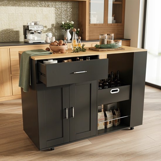 Zwart keukeneiland met houten werkblad, open lade, mandje en open planken. In een keuken.