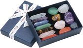 Een blauwe geschenkdoos met een witte strik waarop 'Crystal Jewelry' staat. De doos bevat een assortiment van gepolijste edelstenen en dubbelpuntige kristallen in verschillende kleuren, waaronder paars, groen, roze, oranje en wit.