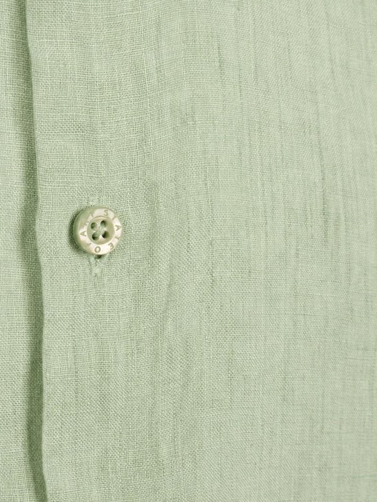Sluiting van een lichtgroen linnen overhemd met een knoop met 'STATE OF ART' logo.