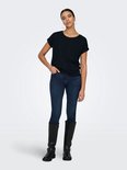 Donkerblauw T-shirt met opgerolde korte mouwen, gedragen door een model met spijkerbroek en laarzen.