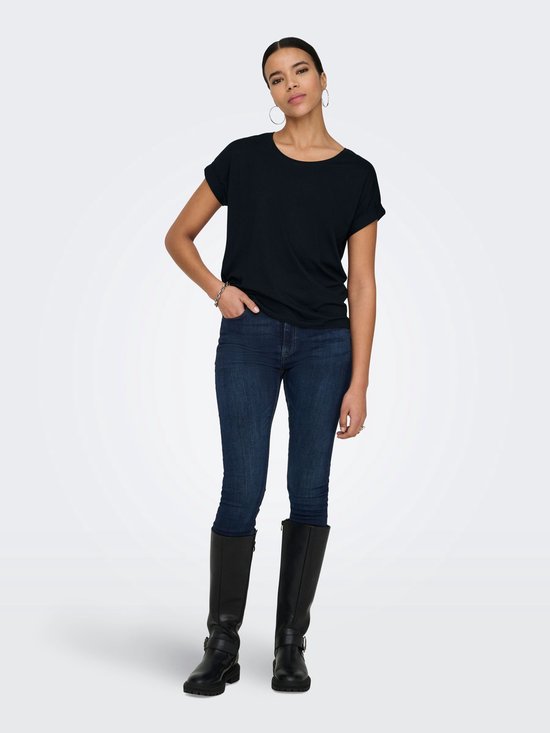 Donkerblauw T-shirt met opgerolde korte mouwen, gedragen door een model met spijkerbroek en laarzen.