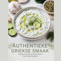 Kom tzatziki met olijfolie, komkommerplakjes en dille. Knoflook en kruiden ernaast.