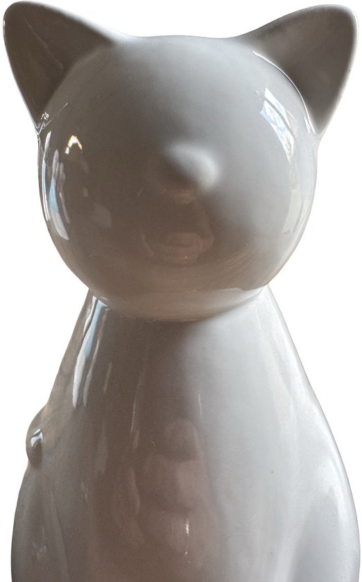 Close-up van de glanzende witte keramische kattenurn, met oren en snuit zichtbaar.