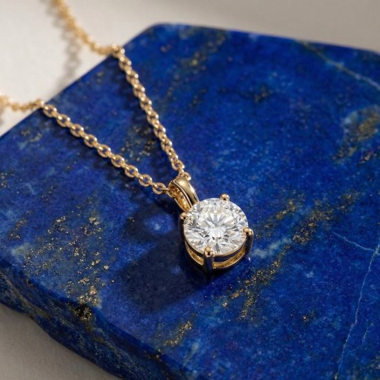 Gouden ketting met zirkonia hanger op een lapis lazuli steen.