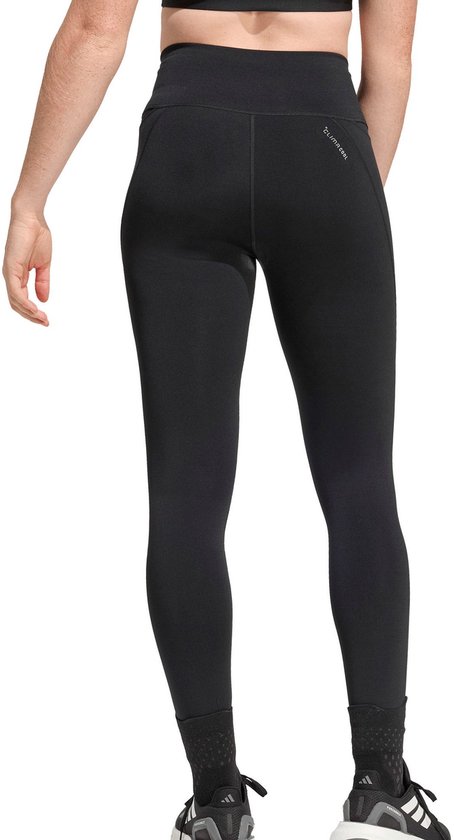 Achterkant model in zwarte Adidas legging met een subtiel patroon op de enkel.