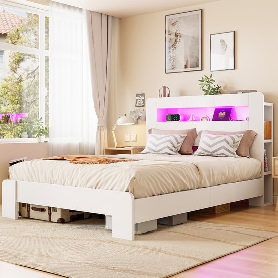 Wit bed met gekleurde ledverlichting in het hoofdbord, opbergvakken aan de zijkant en bedlades.