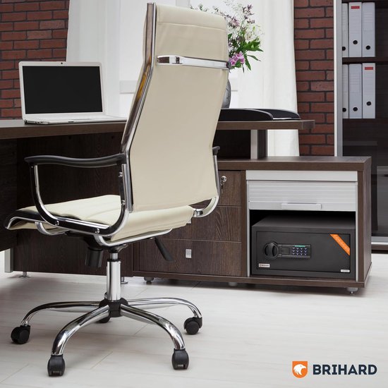 Zwarte Brihard kluis met digitaal slot, geplaatst op een bureau naast een laptop en bureaustoel.