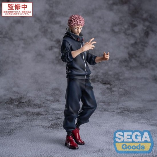Actiefiguur van Yuji Itadori, staand, met roze haar, donkerblauwe hoodie, zwarte broek en rode schoenen.