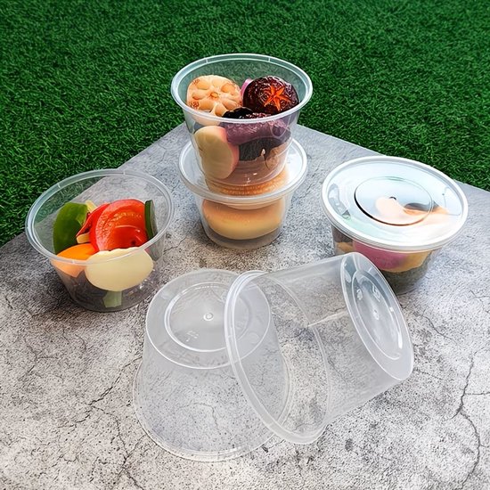 Transparante plastic bakjes met groenten, paddenstoelen en ander voedsel, op een grijze ondergrond.