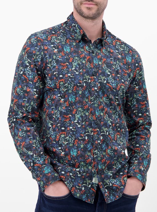 Model draagt een donkerblauw overhemd met lange mouwen en een veelkleurig bloemenprint patroon.