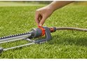 Hand sluit oranje deel aan op de GARDENA zwenksproeier.