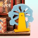 Miniatuur blauwe reuzenrad met een gele standaard, naast een speelgoedwinkel display.