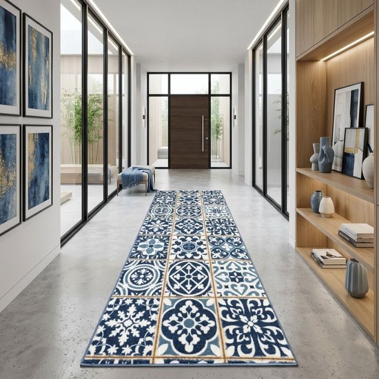 Long couloir avec un tapis bleu et blanc à motif de carreaux sur le sol en béton poli.