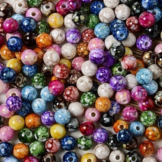 Grote hoeveelheid veelkleurige kralen met marmerpatroon, klaar voor sieraden maken.