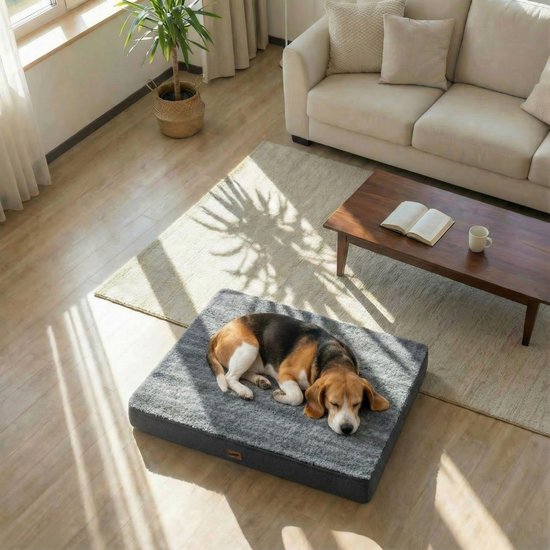 Een beagle slaapt op een donkergrijs hondenkussen met een geribbelde bovenkant.