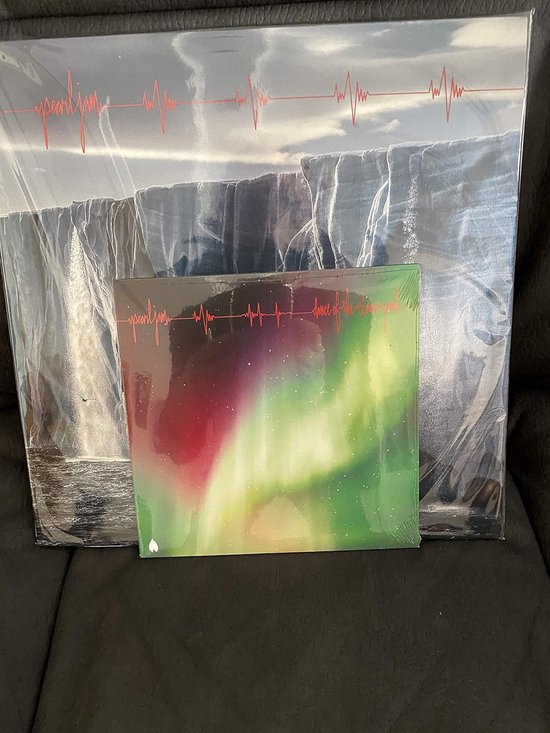 Pearl Jam 7-inch vinyl met noorderlicht en achtergrondalbum met gletsjer en rode hartslaglijn.