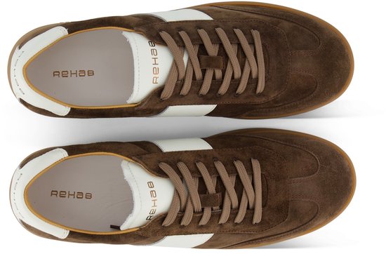 Boven-aanzicht van twee bruine suède sneakers met witte streep.